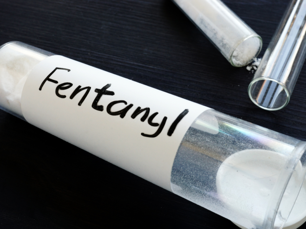 A vial of white powder on its side labeled Fentanyl
